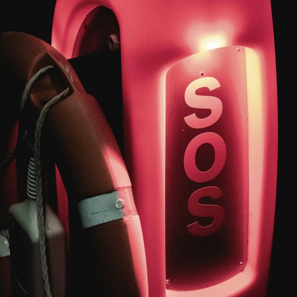 pexels-photo-9658885-9658885 Close-up of an illuminated SOS lifebuoy for emergency rescue at night.
